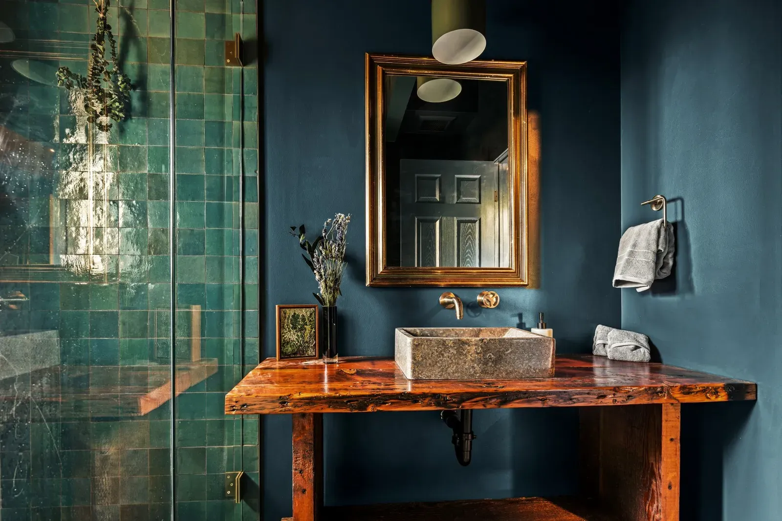 The spa-inspired bathroom features deep green and blue colors inspired by the night sky. The rustic sink and textures remind you that you're in the mountains and have escaped your everyday life.