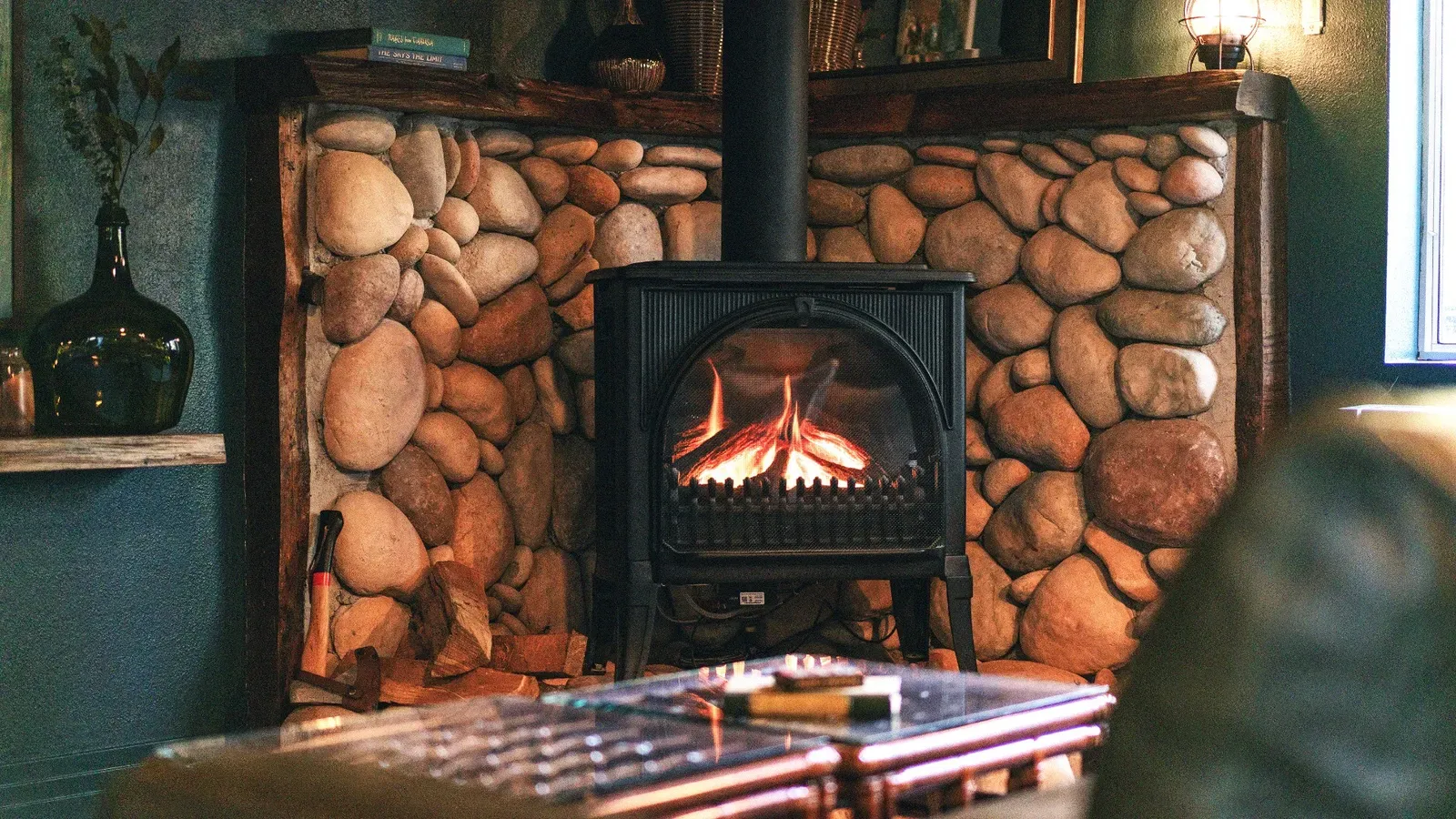 A cozy gas fireplace with rustic stonework is available to warm up the cabin on chilly days or nights.