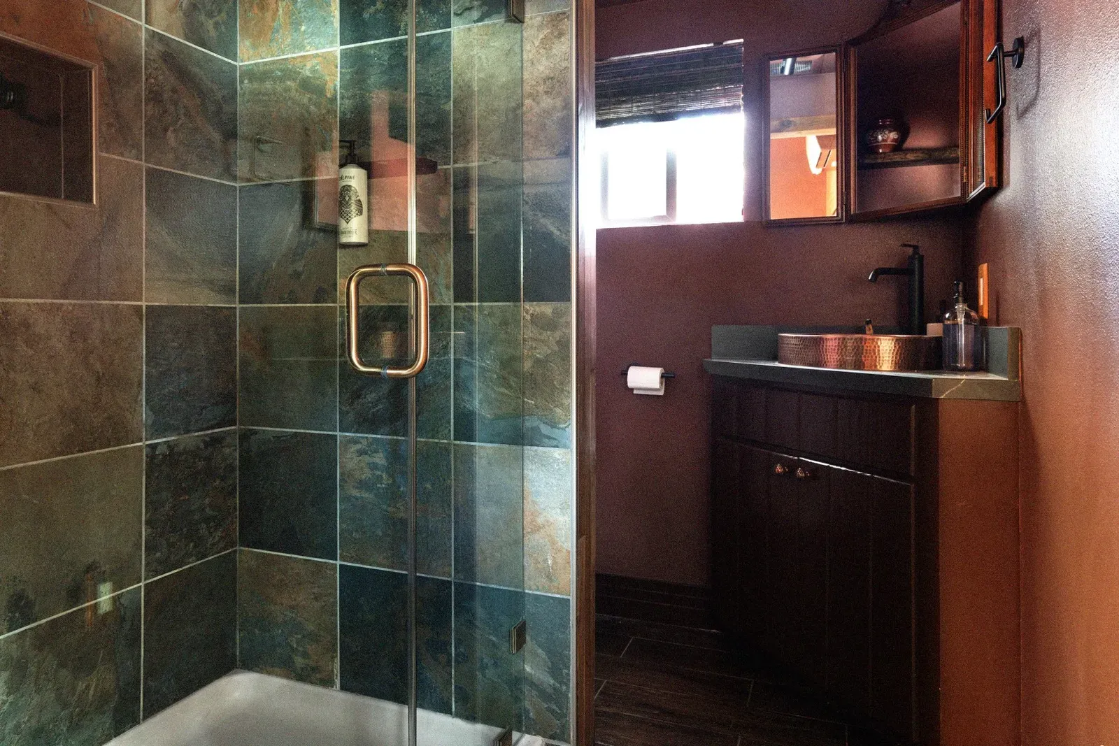 The full bathroom features a tiled shower, complete with toiletries from Alpine Provisions. (The toilet is behind the shower in the corner for privacy.)