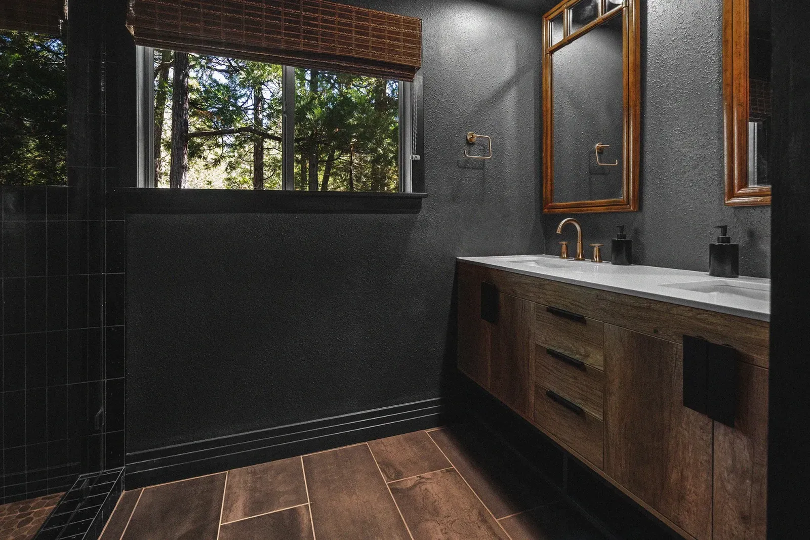 The upstairs bathroom in Ursus features a gorgeous black tile shower and a double vanity.